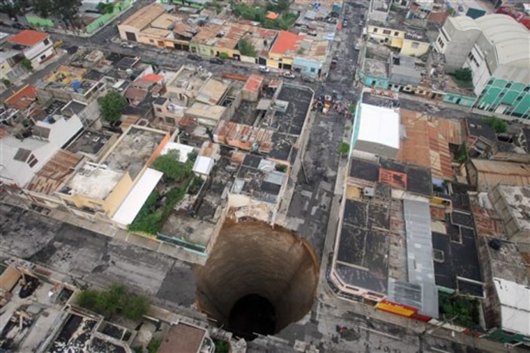 A massive sinkhole covers a street intersection in downtown Guatemala City. Officials blamed the heavy rains for the crater, which swallowed a three-story building. Last April 2007, another giant sinkhole in the same area killed 3 people.